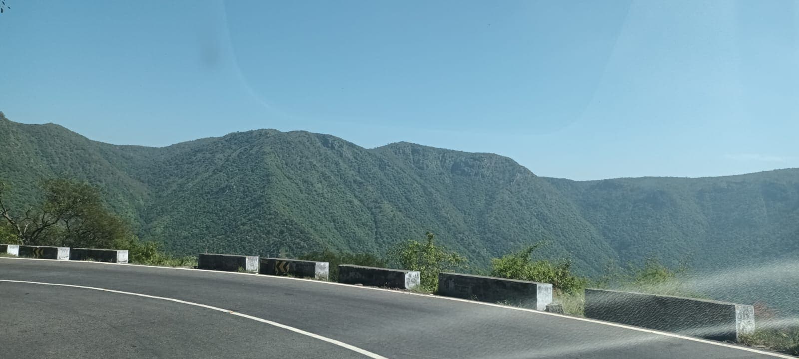 Layered green hills viewed from a curve on a hill-station ghat road